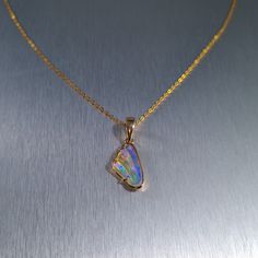 Solid carved Lightning Ridge crystal opal, set in a 14ct yellow gold pendant.  Chain not included. Opal Weight: 2.0ct Size: 16x8.8mm Pendant Length: 26mm Width: 10mm Depth: 4.5mm Materials: Lightning Ridge solid opal, 14ct yellow gold   Total Weight: 1.6gm Opal Cabochon Yellow Gold Jewelry, Yellow Gold Opal Cabochon Jewelry, Gold Opal Pendant Jewelry, Opal Jewelry With Polished Finish For Gift, Yellow Gold Ethiopian Opal Cabochon Jewelry, Iridescent Opal Pendant Jewelry, Gold Ethiopian Opal Cabochon Jewelry, Formal Gold Ethiopian Opal Jewelry, Formal Ethiopian Opal Gold Jewelry