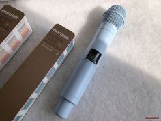 a blue microphone sitting next to a box on top of a white carpeted floor