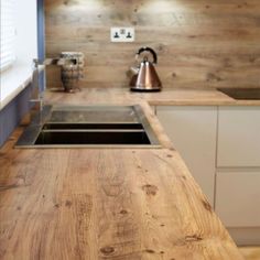 a wooden counter top in a kitchen next to a sink