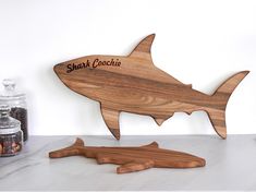 a wooden shark cutout next to a salt and pepper shaker on a counter