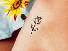 a small sunflower tattoo on the back of a woman's left arm,