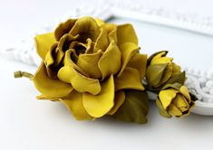 a yellow flower sitting on top of a white table next to a frame with a mirror in the background