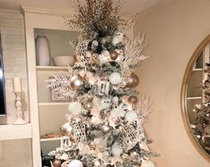 a white christmas tree with silver and gold ornaments