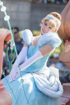 a woman in a blue dress and white gloves