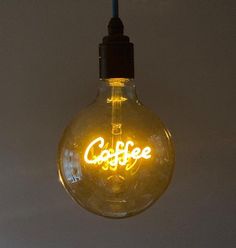 a light bulb with the word coffee lit up in it's center is shown