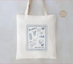 a tote bag with stamps on it and the words charlotte written in blue ink