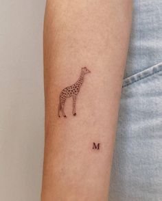 a small giraffe tattoo on the left inner arm and lower arm is shown