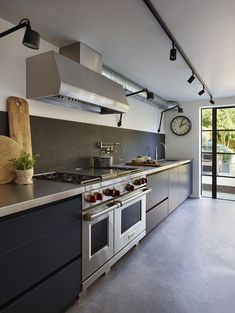 a kitchen with stainless steel appliances and large windows