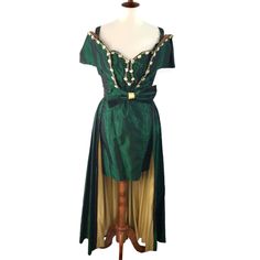 Step Into The Allure Of A Bygone Era With The Vintage Handmade Royal Green Taffeta Beaded Mini Dress With Caplet, Where Timeless Elegance Meets Exquisite Craftsmanship. This Stunning Ensemble Captures The Essence Of Vintage Glamour, Offering A Captivating Blend Of Sophistication And Allure. The Mini Dress Silhouette Accentuates The Figure With Its Tailored Fit. The Caplet Closes At The Front Of The Waist With A Hook And Eye. A Beautiful Bow Snaps On To Cover The Closure. Intricate Faux Pearl Bea Gown Costume, Beaded Mini Dress, You Found Me, Royal Green, Bygone Era, Dress Silhouette, Vintage Glamour, The Vintage, Faux Pearl