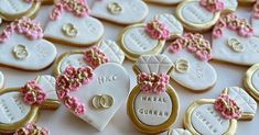 decorated cookies are arranged on a table with wedding rings and heart shaped ones in the middle