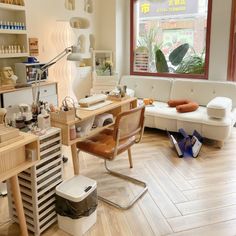 a room with a couch, chair and desk in it that has various items on the floor