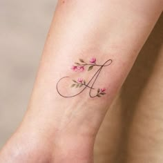 a woman's foot with pink flowers on it and the letter j in script