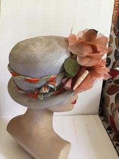 "Vintage 1950's 1960's light Gray Straw hat with Dark Peach flowers. The label is *Grayce Hats*. Does have condition issues and will be sold as is. (SEE PIX). *MORE INFORMATION BELOW* CONDITION: Has discoloration around the inside brim in the front on the straw and on the band/ribbon (SEE PIX). On the inside band on the right side there is a small dark spot. In the back of the hat on the brim area there is some wear. This appears to be from where the hatpin was always used (SEE PIX). Sold As Is! Vintage Brimmed Mini Hats For Garden Party, Vintage Spring Cloche Hat With Curved Brim, Vintage Cloche Hat With Curved Brim For Spring, Vintage Gray Brimmed Hat, Vintage Cloche Hat For Spring, Retro Spring Cloche Hat, Vintage Fitted Hat For Spring, Vintage Mini Hats For Kentucky Derby Garden Party, Fitted Vintage Hats For Spring