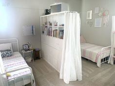 a bedroom with two beds and a book shelf