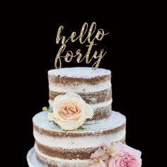 a three tiered cake with flowers on top and the word hello forty written in gold