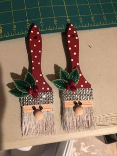 two red and white christmas decorations sitting on top of a table next to a ruler