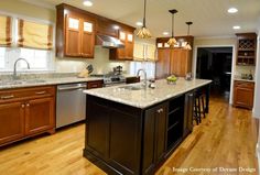 a large kitchen with wooden cabinets and stainless steel appliances, along with hardwood flooring