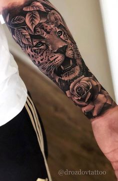 a man's arm with a tiger and roses tattoo on it