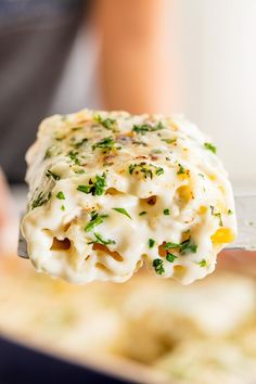 a close up of a person holding a spoon with some food on top of it