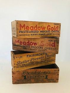 four wooden boxes stacked on top of each other with the words meadow gold painted on them