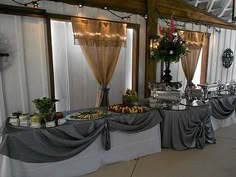 a banquet hall with long tables covered in gray cloths and white tablecloths