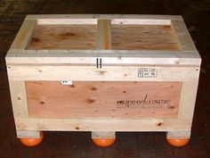 a wooden box sitting on top of orange wheels