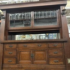 an old wooden cabinet with glass doors and drawers