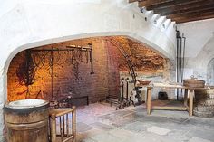 an old fashioned kitchen with brick walls and stone floors