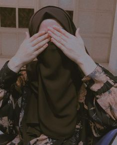 a woman covering her face with both hands