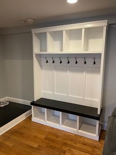 a room with some white cabinets and black bench