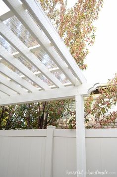 a white wooden pergoline on the side of a house