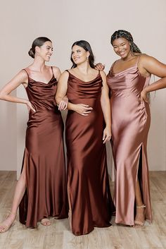 three women standing next to each other in dresses