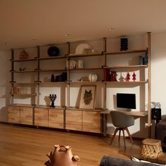 a living room filled with furniture and a flat screen tv sitting on top of a wooden shelf