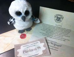 a stuffed owl sitting on top of an envelope next to a harry potter letter and seal