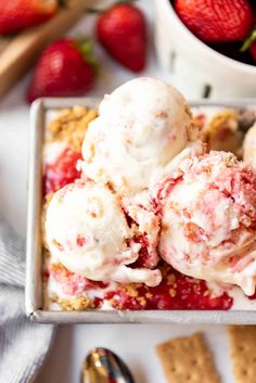 a white bowl filled with ice cream and strawberries on top of a wooden table