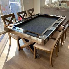 a pool table with chairs around it in the middle of a living room and dining room