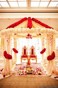 the wedding stage is decorated with red and white flowers