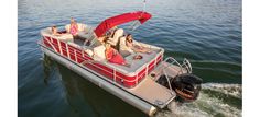 two women are sitting on the back of a red pontoon boat in the water