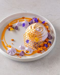 a white plate topped with purple and yellow flowers