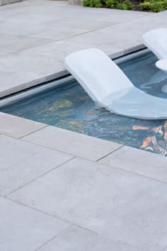 two white chairs sitting on top of a swimming pool next to a fire hydrant