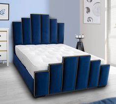 a bed with blue velvet headboard and foot board