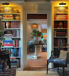 a living room filled with lots of books and furniture