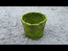 a green vase sitting on top of a white rug