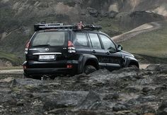 a black jeep driving down a rocky road