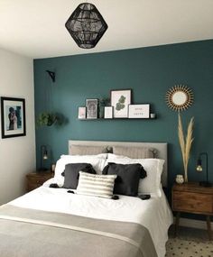 a bedroom with teal walls and white bedding