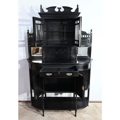 an antique black china cabinet with glass doors