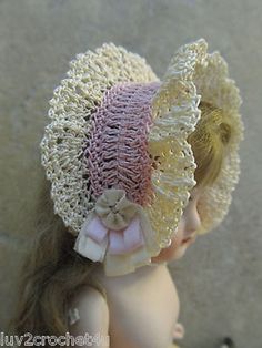 the doll is wearing a crocheted hat with flowers on it's brim