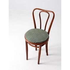 a wooden chair with a checkered seat cushion on it's back and side