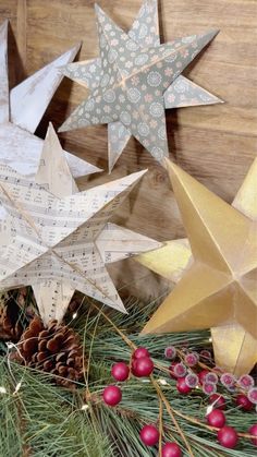 three paper stars on top of evergreen branches