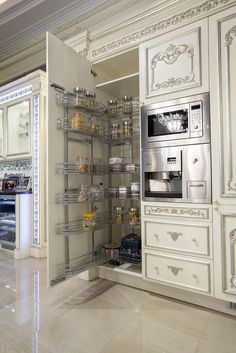 a kitchen with white cabinets and shelves filled with food in the center, including an oven